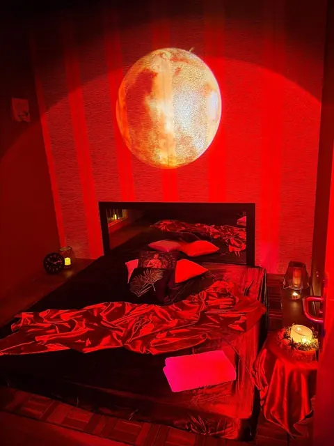 Sala de tatami de Eva Luna en Murcia con luz roja y luna proyectada